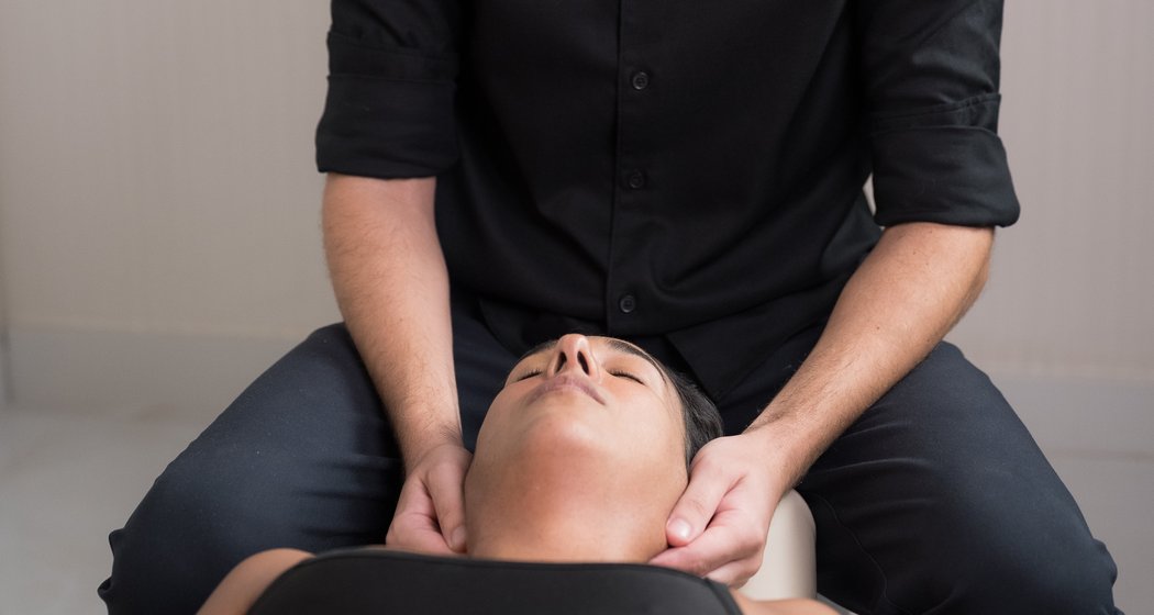 Quiropraxista realizando ajuste cervical em paciente na Clínica Bagatini
